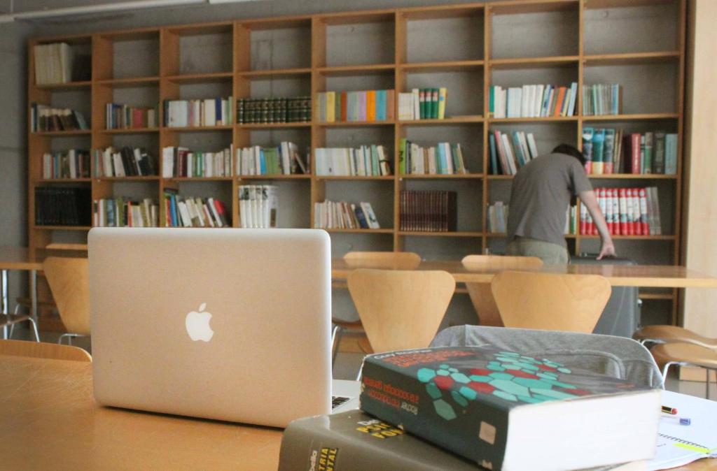 a laptop computer sitting on a table in a library at Residència Universitària Sant Joan in Reus