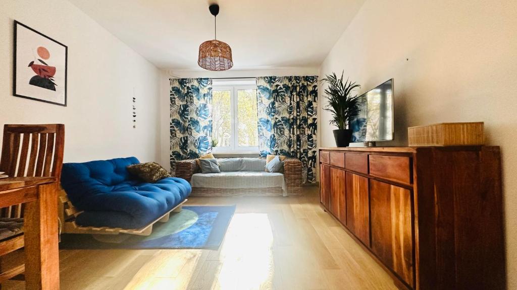ein Wohnzimmer mit einem blauen Sofa und einem Fenster in der Unterkunft M&M Apartment Warsaw in Warschau