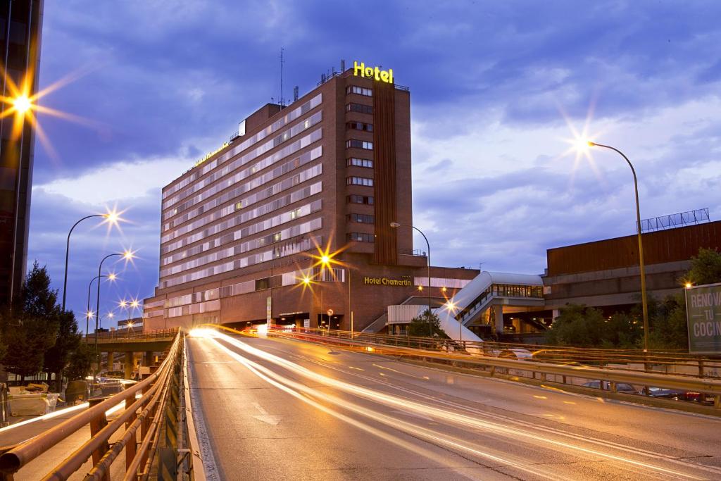 um edifício de hotel numa rua da cidade à noite em Hotel Chamartin The One em Madri