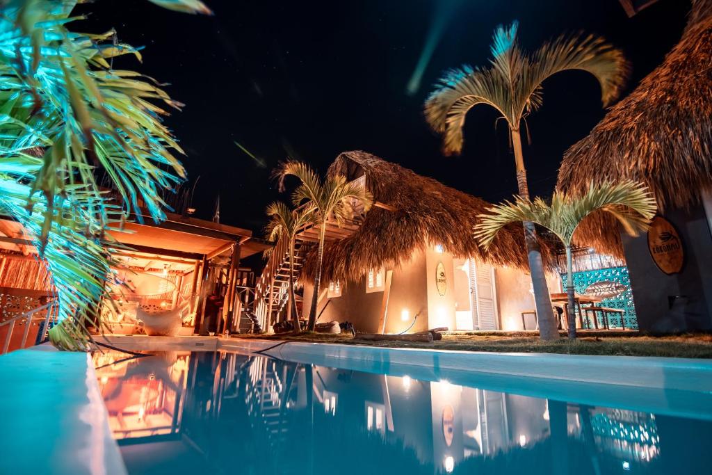 - une piscine bordée de palmiers en face d'une maison dans l'établissement KokohauBungalows, à Santa Veronica