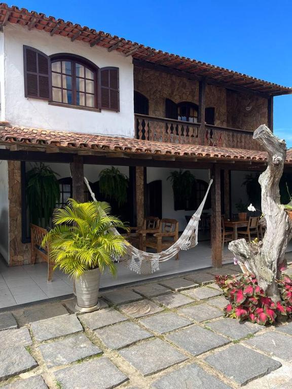 una casa con una hamaca delante en Casa Canto da Serra en Búzios