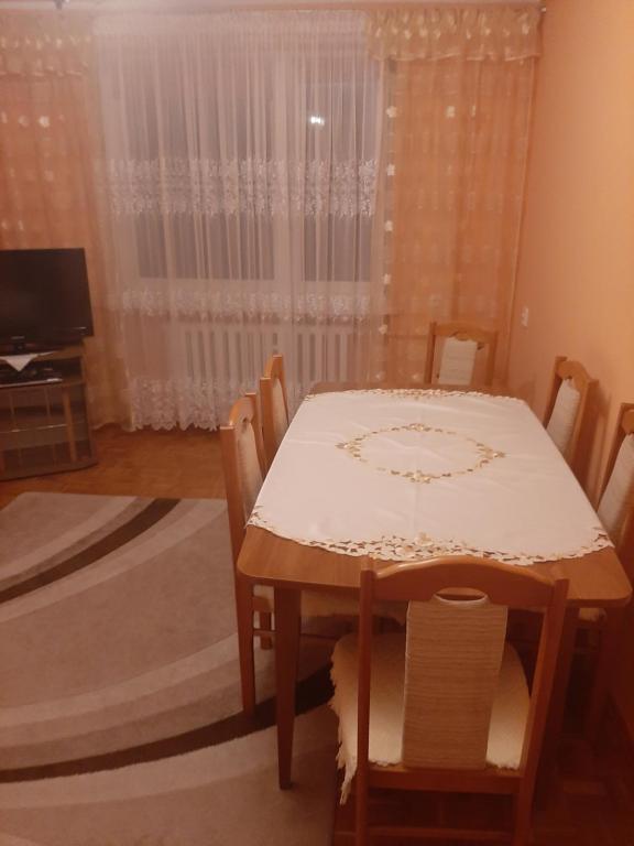 a dining room with a table and chairs and a window at Centrum in Koło