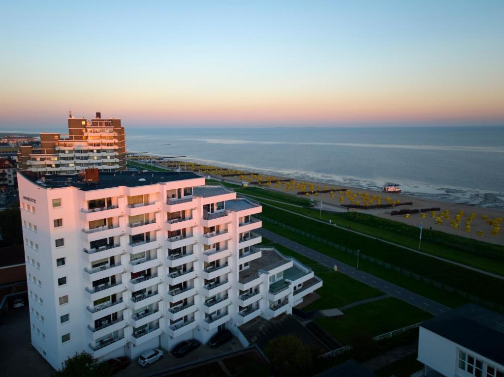 un edificio rosa con el océano en el fondo en Apartment im Haus Hanseatic mit Meerblick am Duhner Sandstrand, en Cuxhaven