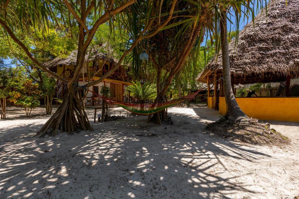 una hamaca colgando entre dos árboles en una playa en Eden Paradise, en Michamvi