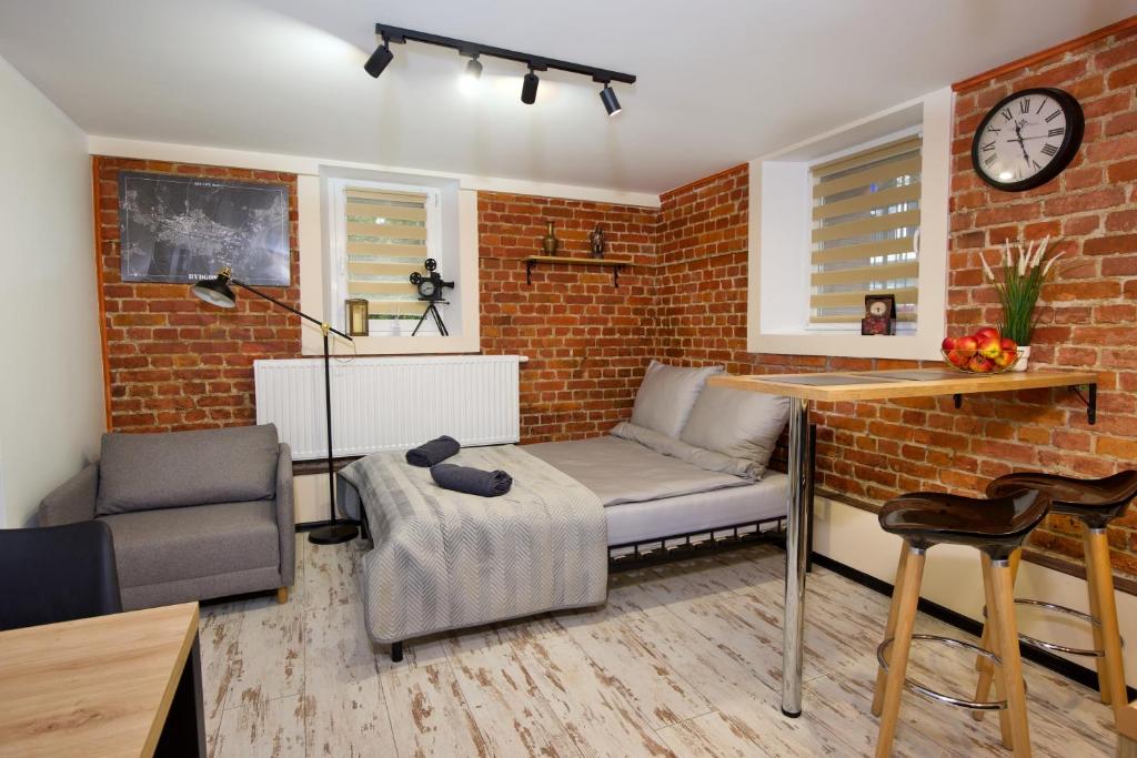 a living room with a couch and a brick wall at LOFTY CHOPINA in Bydgoszcz