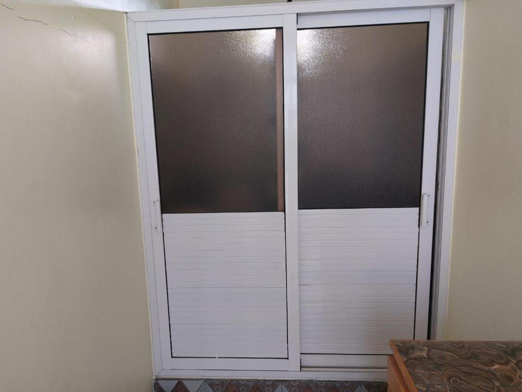 a pair of sliding doors in a room at Rental Furnished Studio in Port Louis