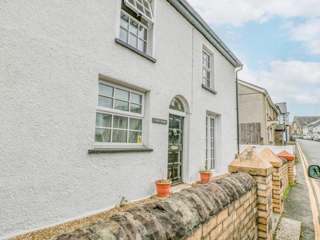 Cette maison blanche est dotée de fenêtres et d'un mur en briques. dans l'établissement Builth House, à Abergavenny