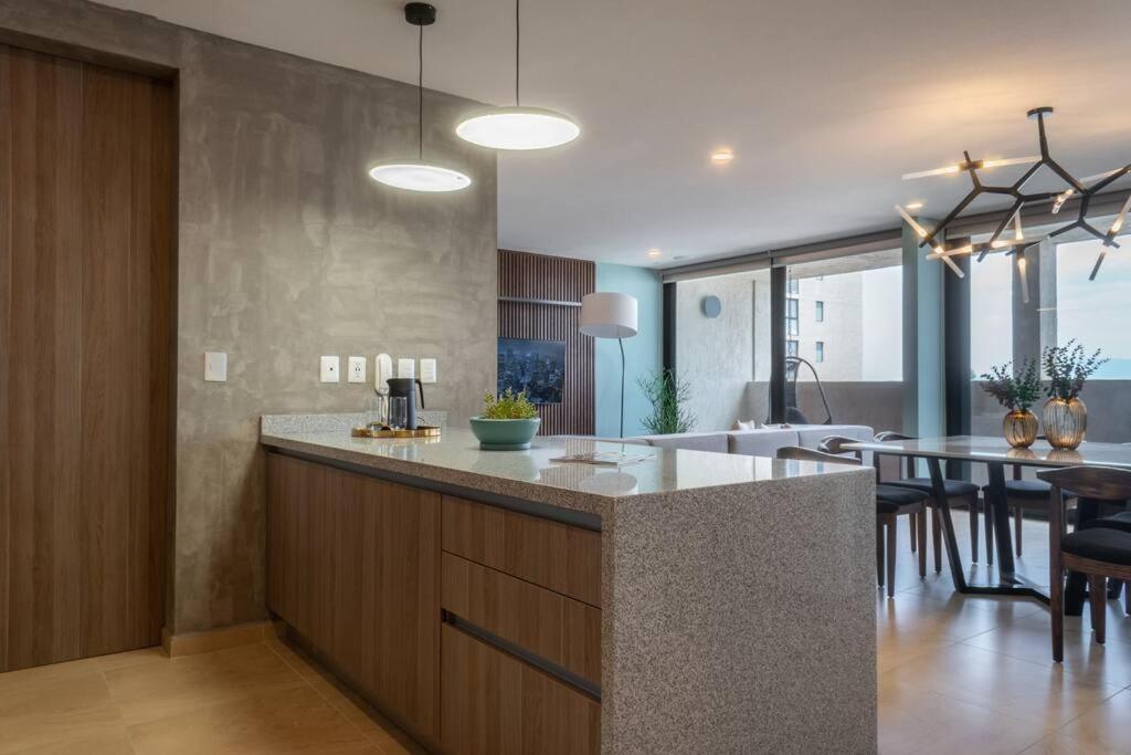 a kitchen and living room with a counter and a table at Nuevo Departamento en Zibatá Querétaro, 4 Personas in La Cañada