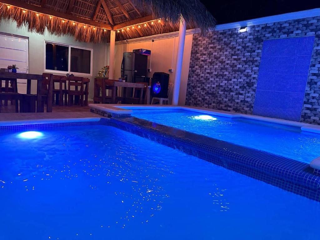 une piscine éclairée par des lumières bleues dans l'établissement Posada chachalacas, à Chachalacas