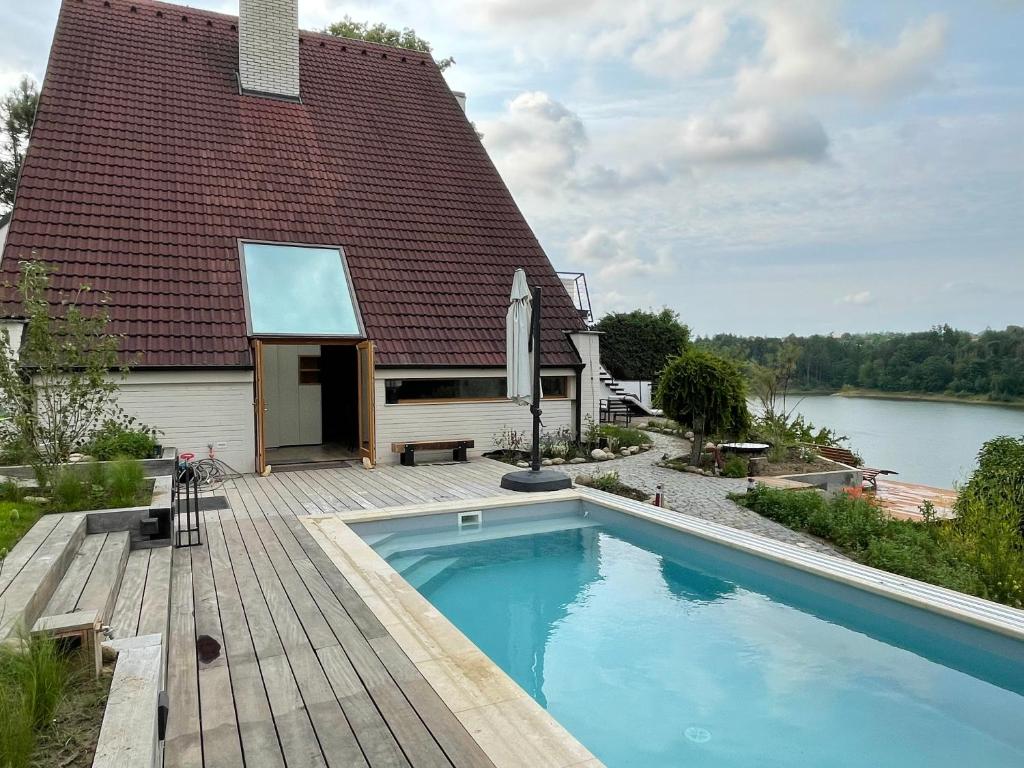 een huis met een zwembad naast een gebouw bij Dům nad přehradou s bazénem in Lazinov