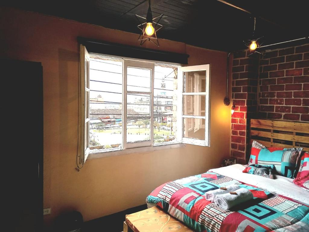 a bedroom with a bed and a brick wall at Donde Pepe Loft Apartasuite. in Zipaquirá