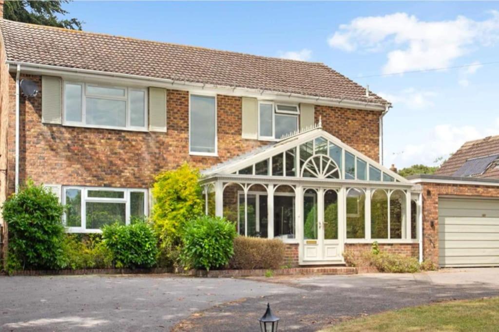 a brick house with a glass conservatory at Wonderful House In Winchester in Wonston