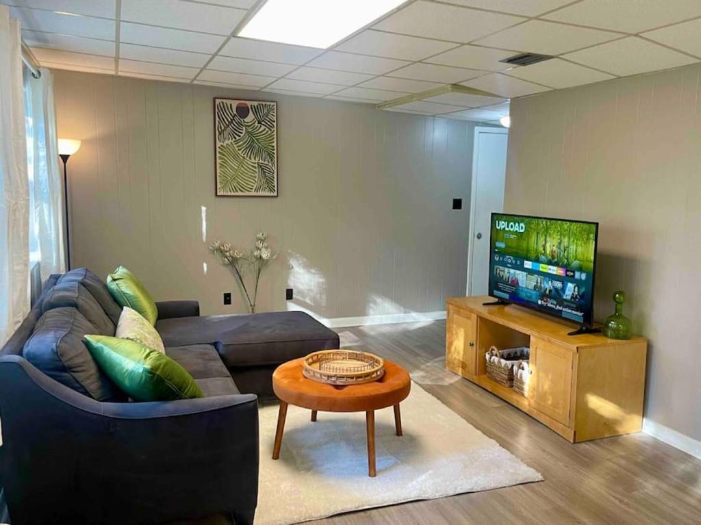 a living room with a couch and a television at Midtown at Marion Green 1BR 1BA, 2 miles FAMU FSU, 2blks TMH in Tallahassee