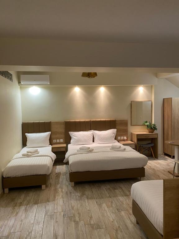 a hotel room with two beds and a bathroom at SUNIBELROOMS in Paralia Katerinis