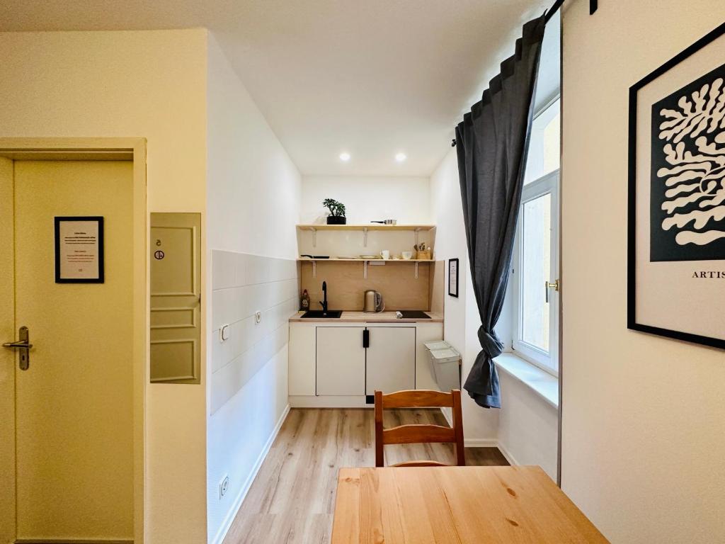 eine kleine Küche mit einem Holztisch und einem Fenster in der Unterkunft Saale, Marktplatz Zentrum, Apartmenthaus am Dom von Plant Room in Halle an der Saale