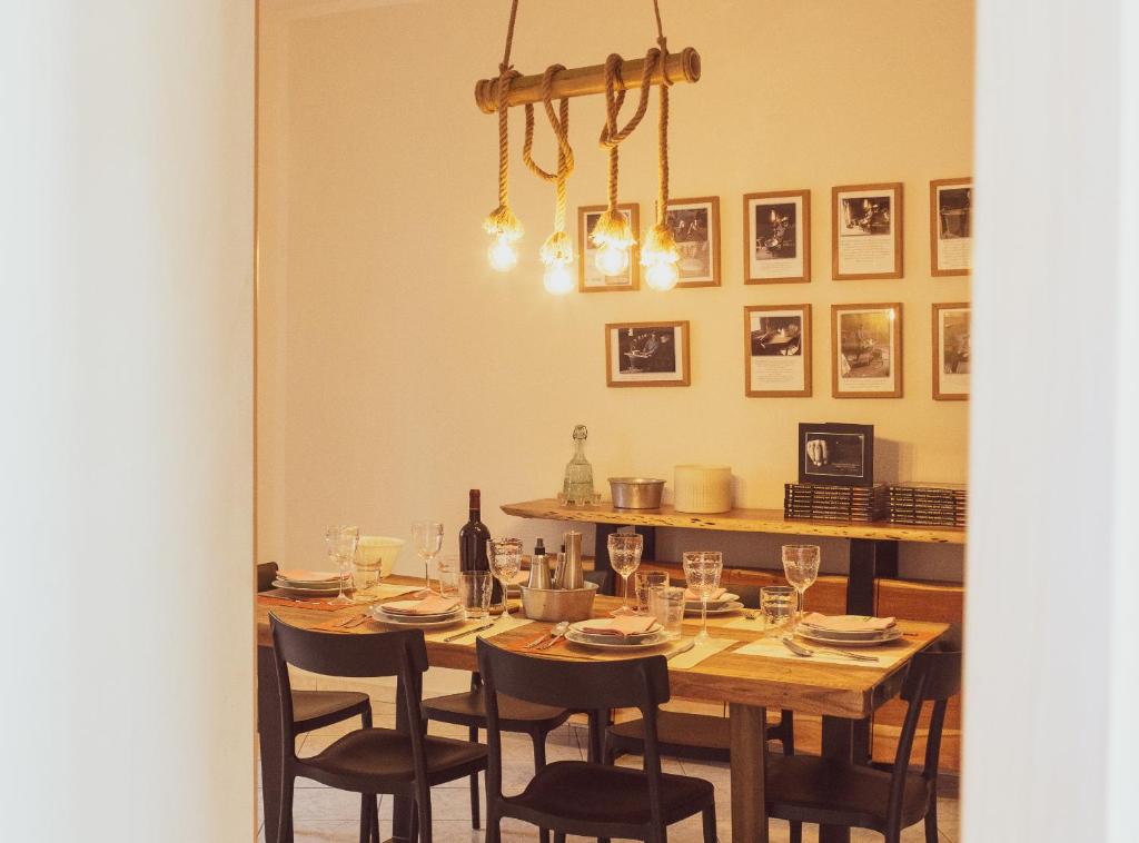 una mesa de comedor con sillas y una botella de vino en Domo de Ciu Nenneddu en Oliena