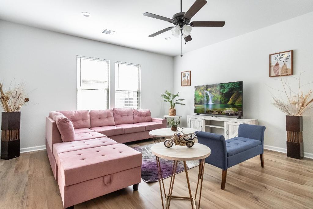 sala de estar con sofá rosa y sillas azules en La Vida Loca, en Baton Rouge
