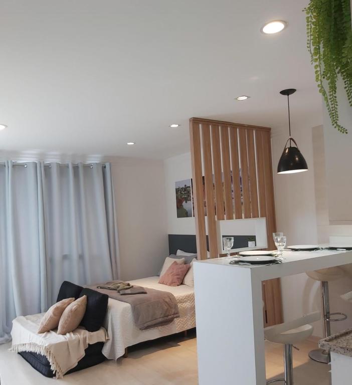 a bedroom with a bed and a desk in a room at Lindo studio equipado em apartamento clube com academia e conforto no centro de Curitiba - MID Home in Curitiba