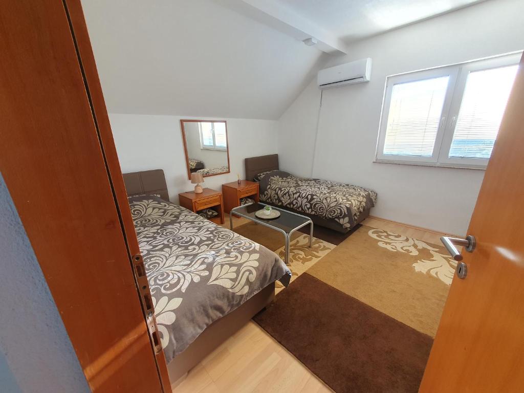 una piccola camera con un letto, un piccolo letto e uno specchio di House Apartment Azra a Sarajevo