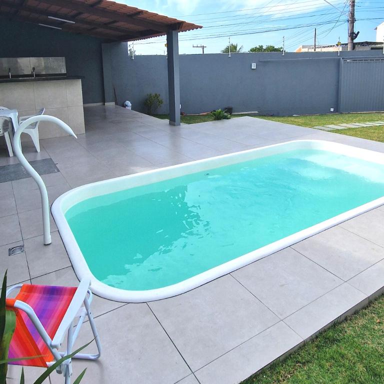 a large swimming pool on a patio with a chair at Casa do Sol - Nova Guarapari in Guarapari