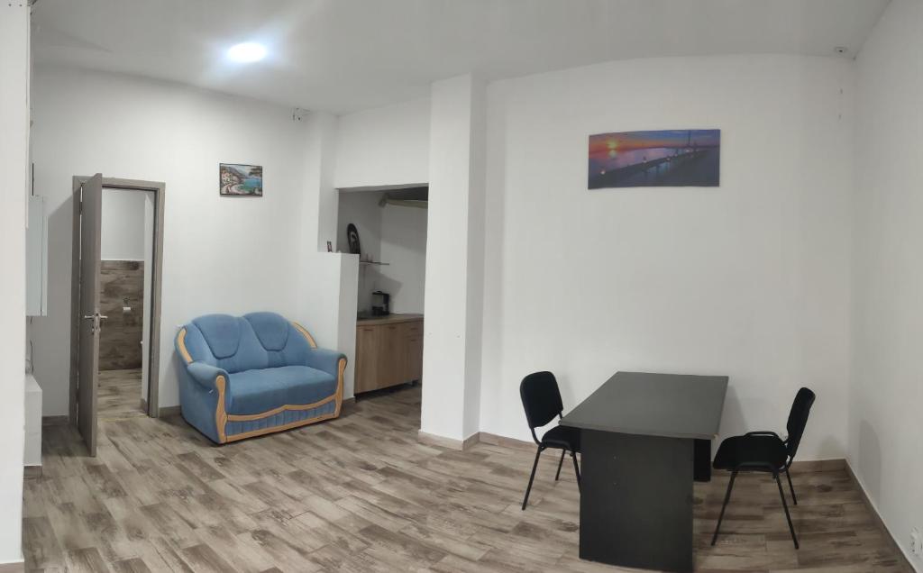 uma sala de espera com uma cadeira azul e uma mesa em Apartament Karina em Baia Mare