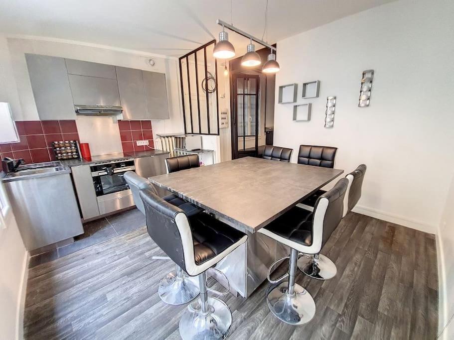 eine Küche mit einem großen Holztisch und Stühlen in der Unterkunft Vincennes superbe appartement en rdc in Vincennes