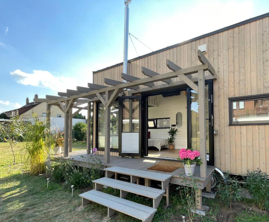 a house with a pergola on the side of it at Tinyhaus Marie von Tinyhaus Steinhude in Steinhude