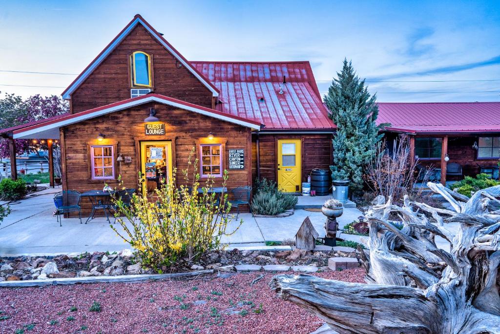 uma cabana de madeira com um telhado vermelho em The Loubird Inn em Escalante