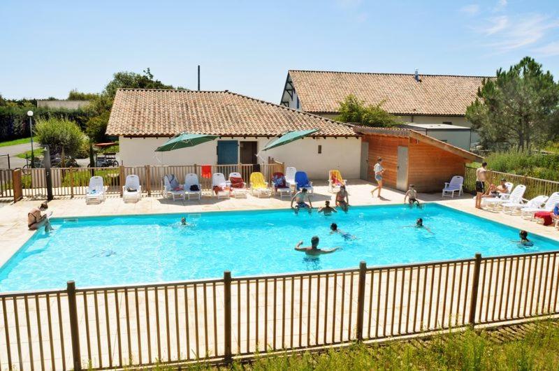 a group of people in a large swimming pool at La palombe in Orist