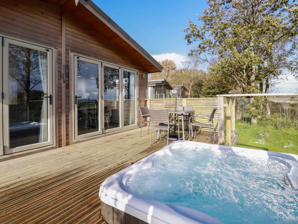 a hot tub on a deck next to a house at 20 Meadow Retreat in Liskeard