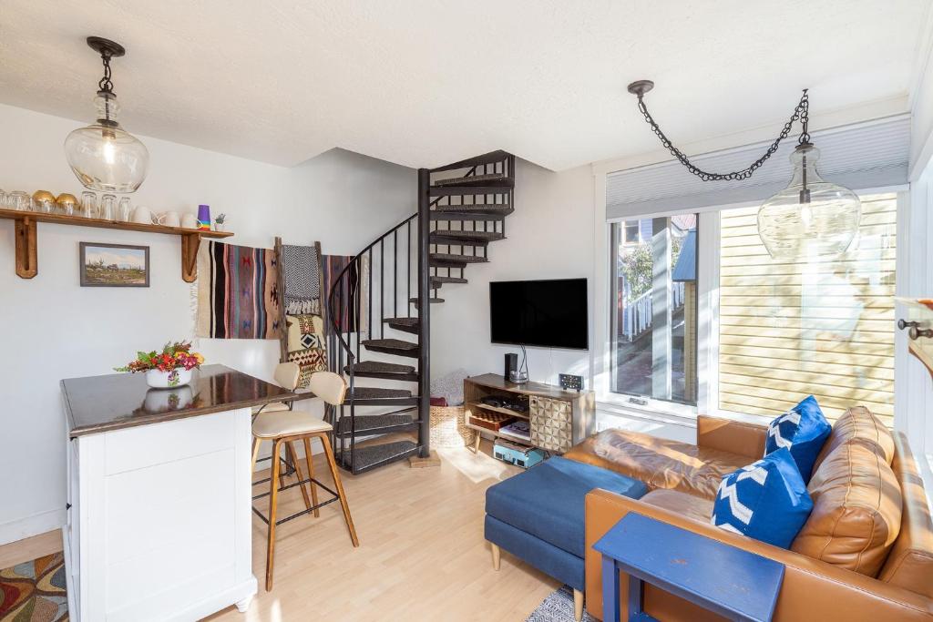 a living room with a blue couch and a staircase at Style & Location! Steps to Gondola, Main Street, River condo in Telluride