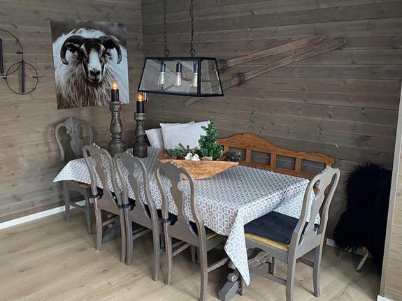 a dining room table and chairs with a cow painting on the wall at Fjellhytte på Hovden in Hovden