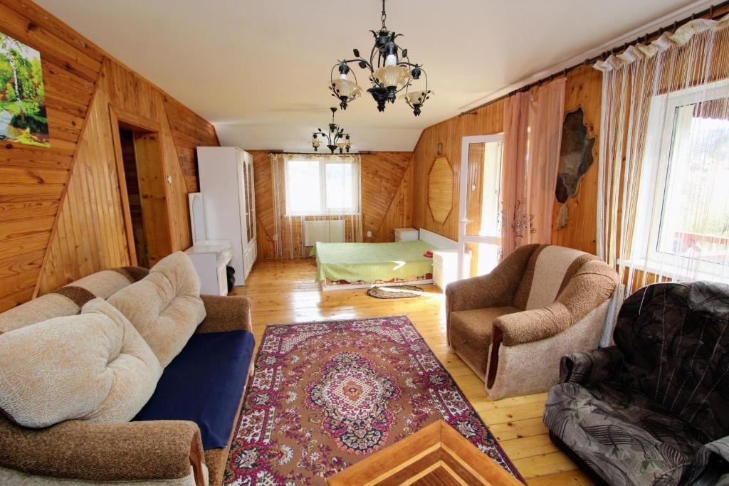 a living room with wooden walls and a chandelier at Садиба "Наталі" in Yaremche
