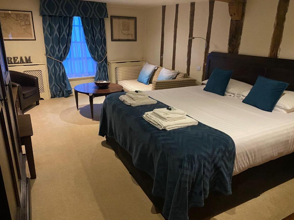 a hotel room with a large bed with blue pillows at Samuel Pepys in Harwich