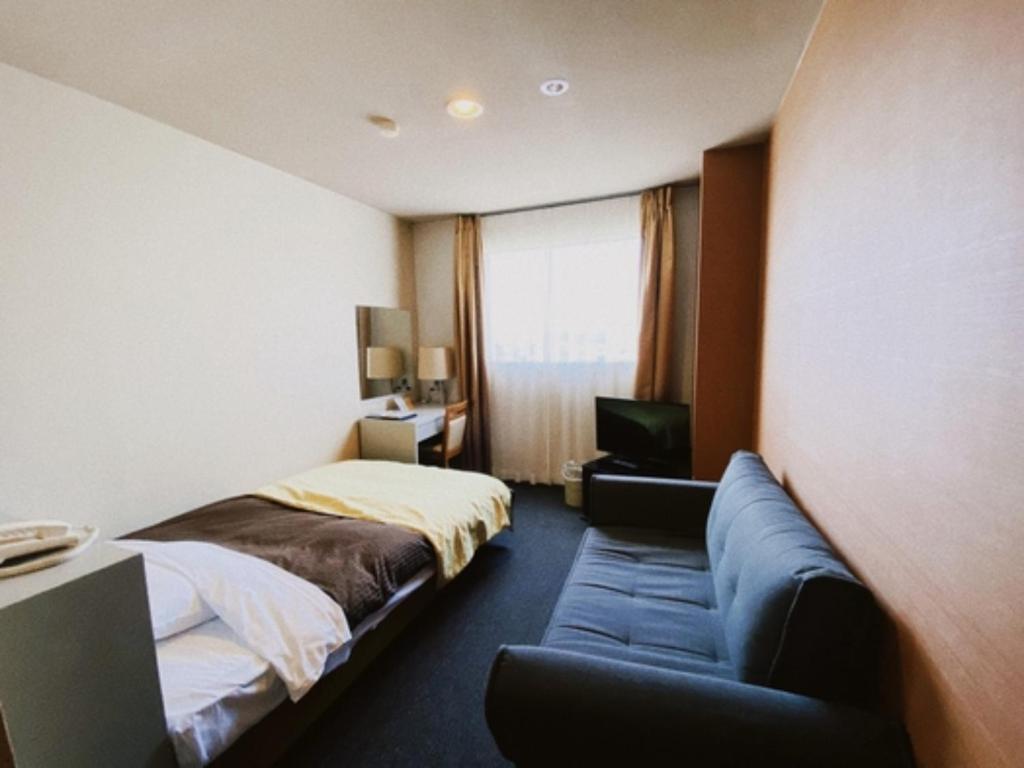 a hotel room with a bed and a couch at Hotel 1-2-3 Maebashi Mercury - Vacation STAY 01042v in Maebashi