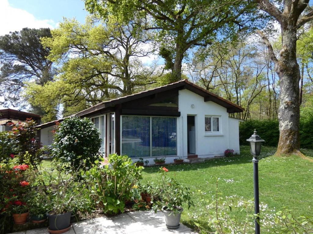 een klein wit huisje met een tuin bij Le mont in Saint-Geours-de-Maremne