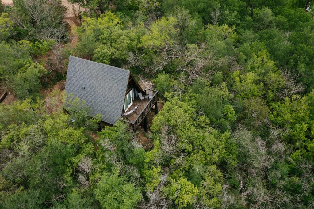 an aerial view of a small house in the woods at The Maverick: A-Frame w/ Hammock and Tree Top View in New Braunfels