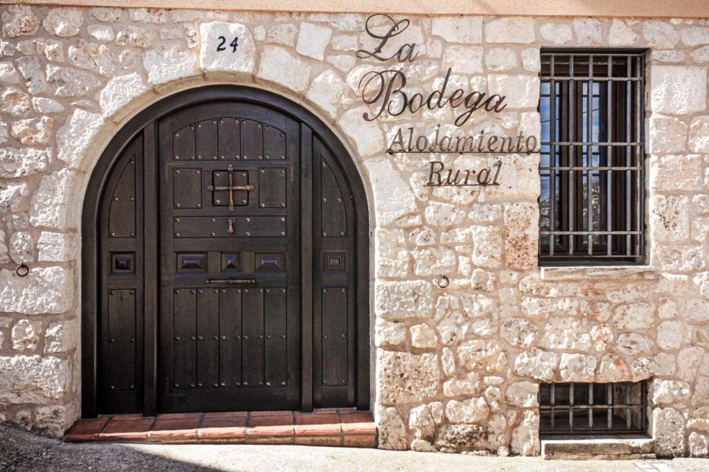 un edificio con una puerta y una señal en él en Casa Rural LA BODEGA, ofrece cata de vino gratis en Horche