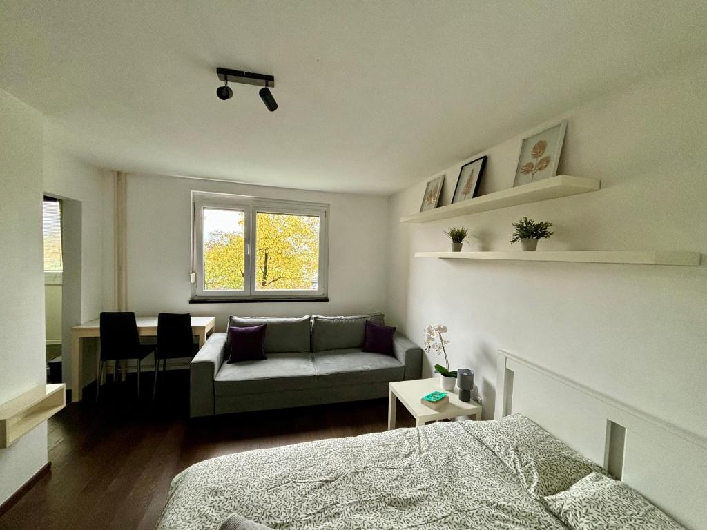 sypialnia z łóżkiem i kanapą w obiekcie Flat near BTC city - free parking w Lublanie