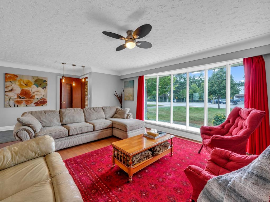 a living room with a couch and two chairs at Park Bungalow - Seacliff Beach Suites in Leamington