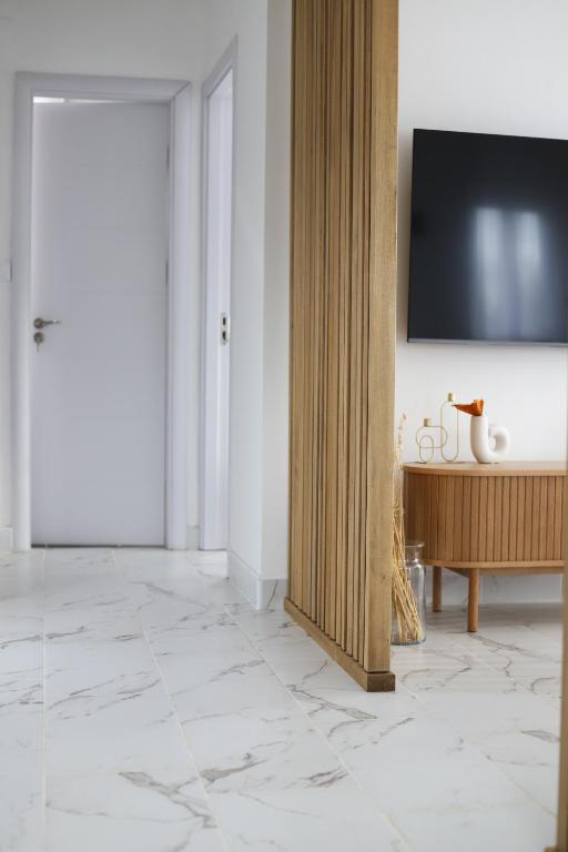 a living room with a television on a wall at Vrh Apartman in Divčibare