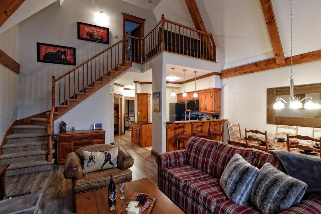 a living room with a couch and a staircase at Plateau B - Mont-Tremblant in Mont-Tremblant