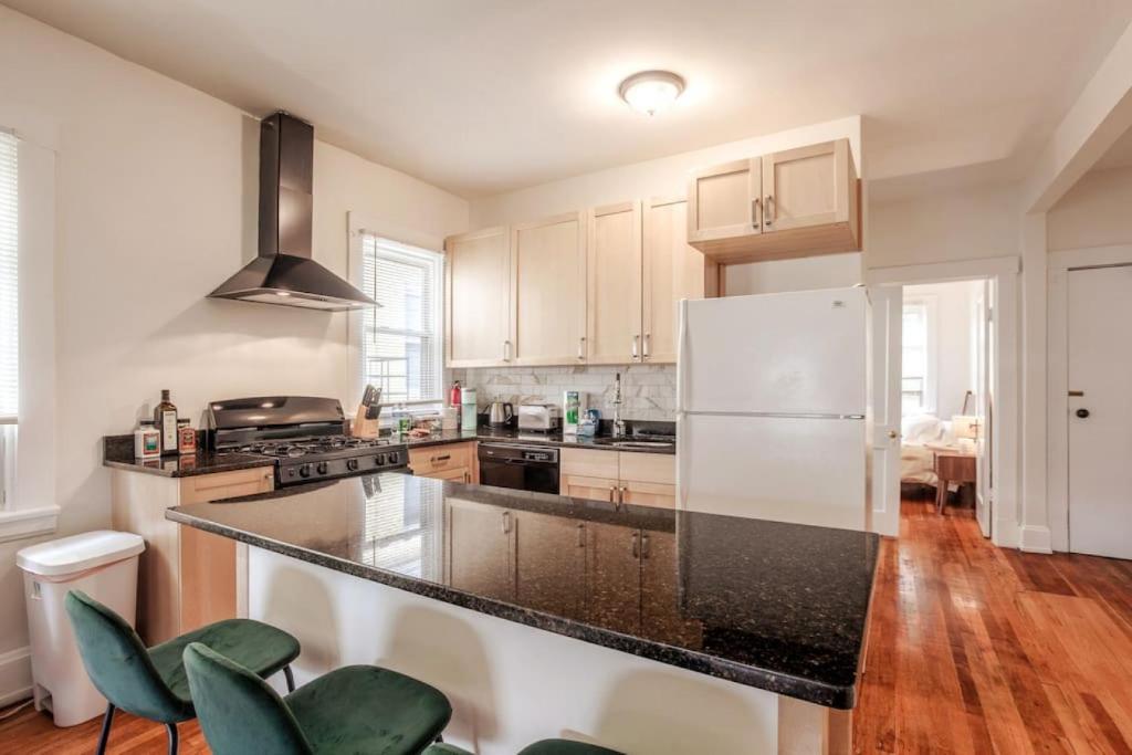eine Küche mit einem weißen Kühlschrank und Holzböden in der Unterkunft The Villa Emerald 1B Walk to Downtown Covington in Covington