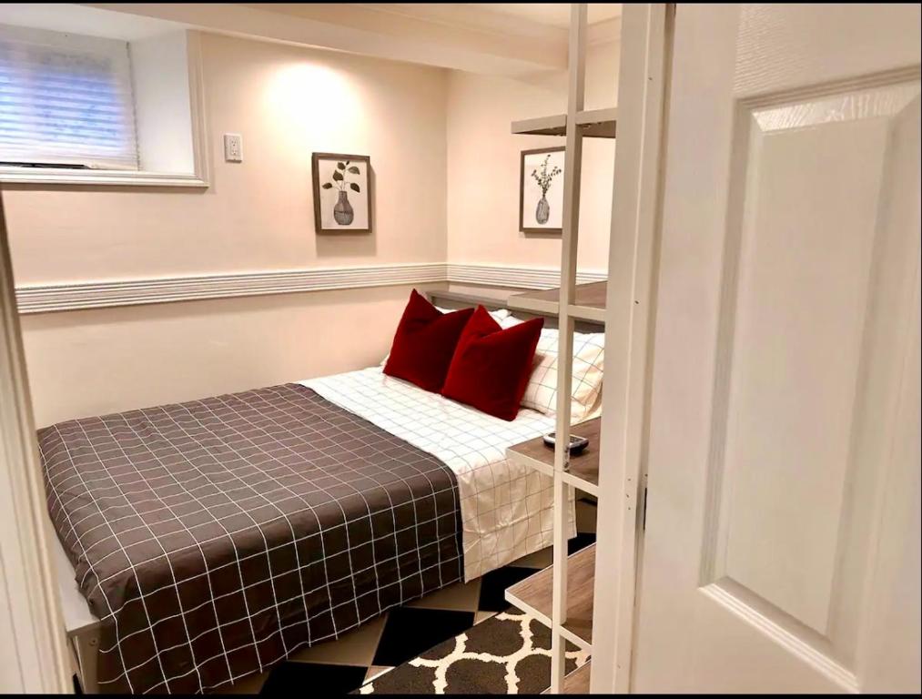 małą sypialnię z łóżkiem z czerwonymi poduszkami w obiekcie 5-A Diamond in Yonkers w mieście Yonkers