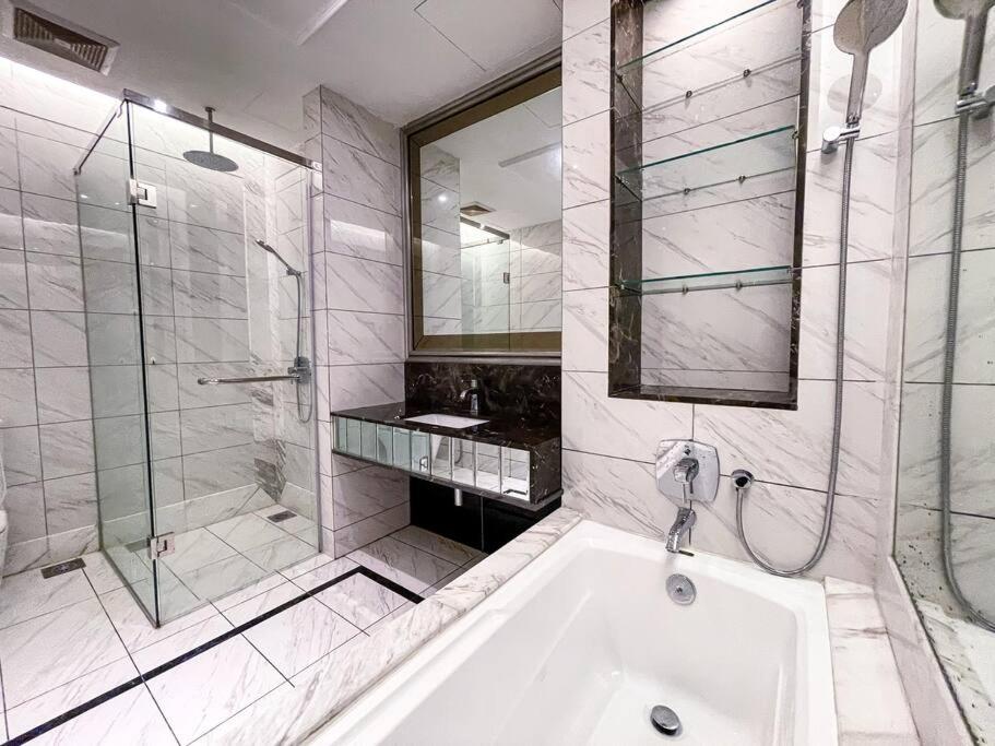 een witte badkamer met een bad en een douche bij Skypool Couple Suite in Sri Hartamas KL in Kuala Lumpur