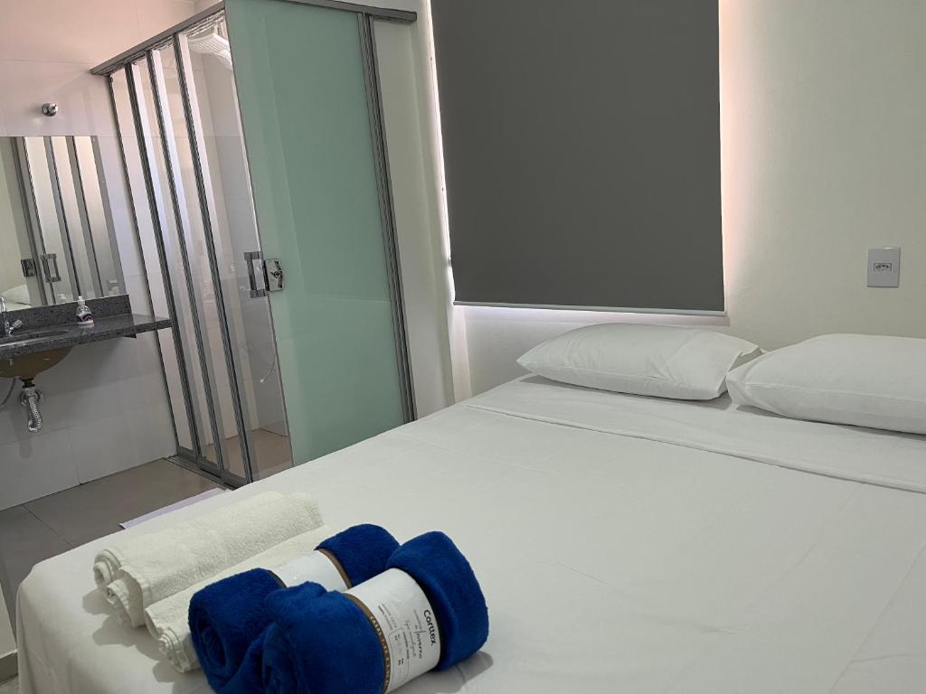 a bedroom with a bed with blue towels on it at Apartamento em Uberlândia - Apê do Pedro in Uberlândia