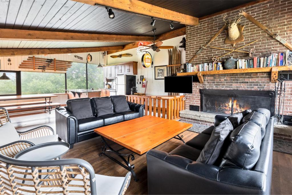 a living room with leather furniture and a fireplace at Semi Detached Mountain View Chalet in Blue Mountains