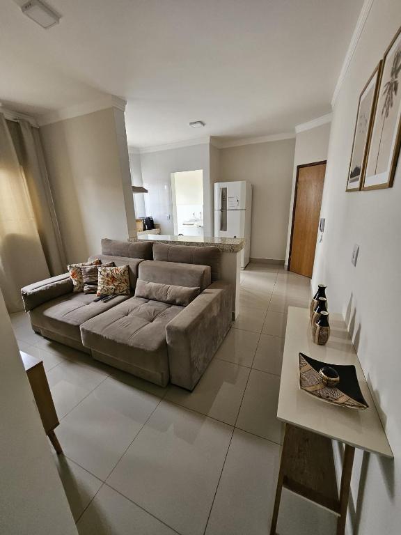 sala de estar con sofá y mesa en Apartamento Completo - Algarve 203 e 204, en Patos de Minas