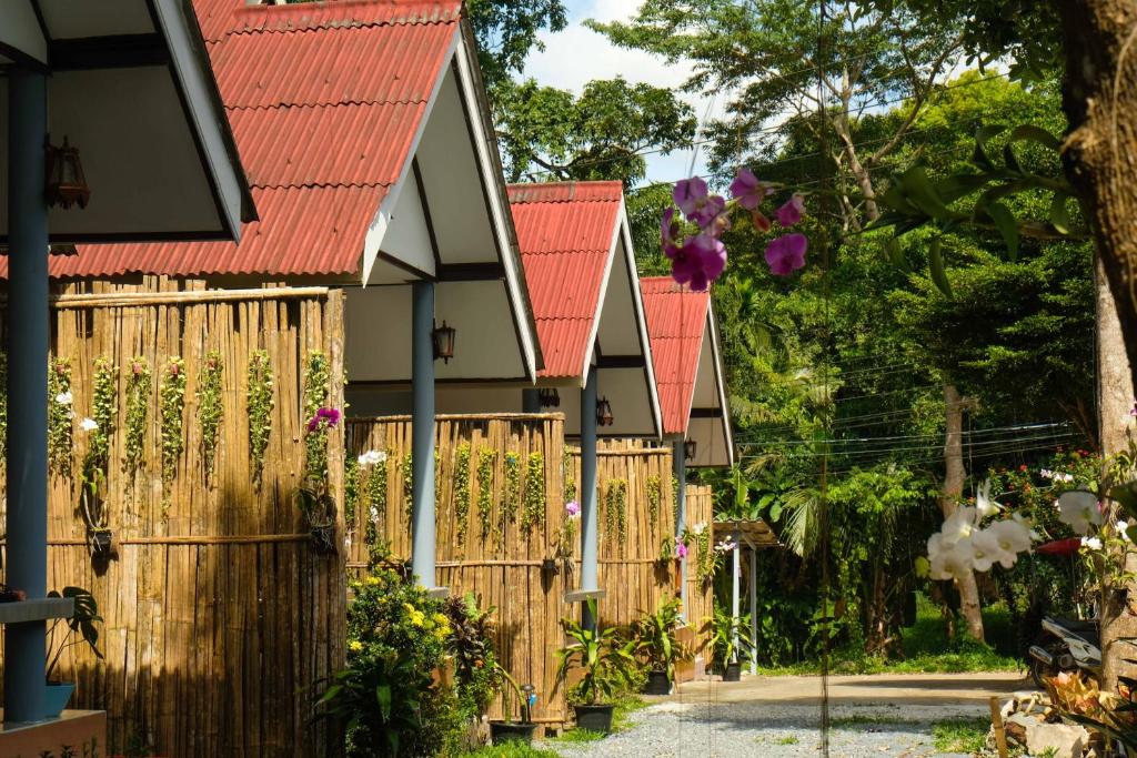 une rangée de maisons avec des toits rouges et une clôture en bois dans l'établissement KANNIKA RESORT, à Ko Chang