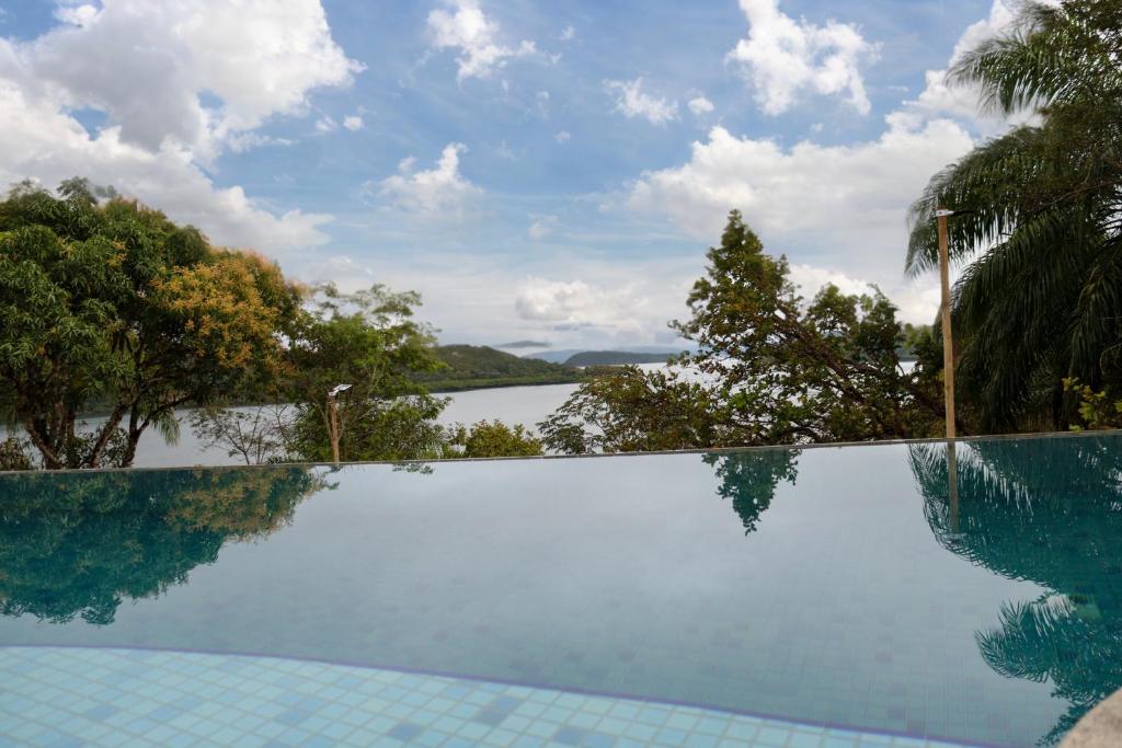 a swimming pool with a view of a body of water at Ilha privativa - Rio Paraguaçu in Cachoeira